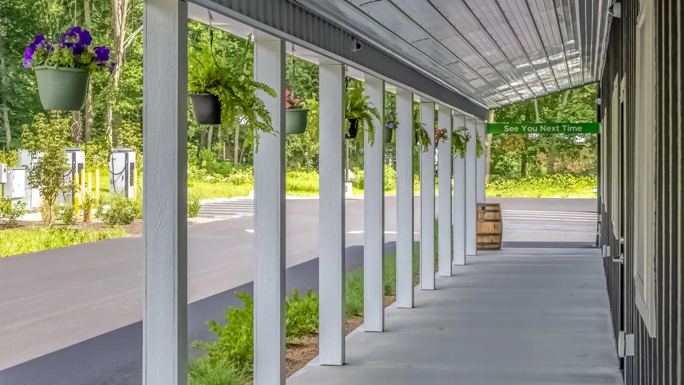 Covered porch of Farmers Choice dispensary with hanging flower baskets