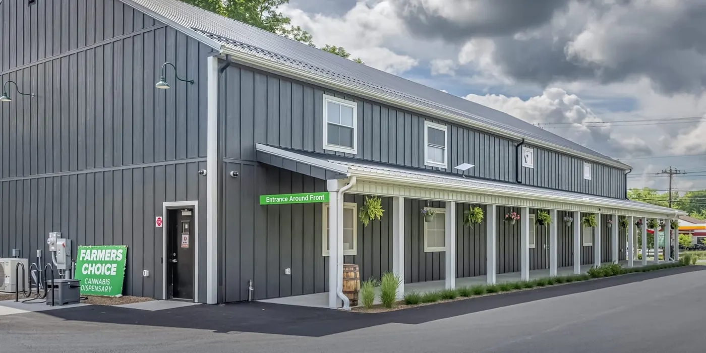 Side view of Farmers Choice dispensary building with green sign